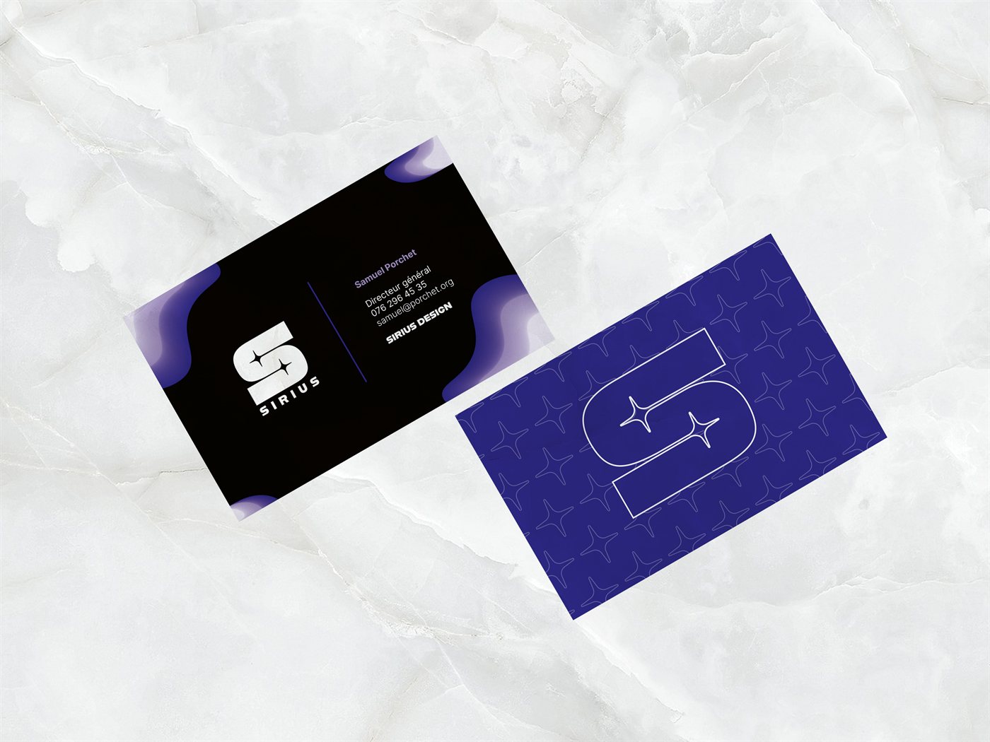 Cartes de visite Sirius recto-verso posées sur du marbre, recto noir avec le logo et verso violet au motif d'étoiles